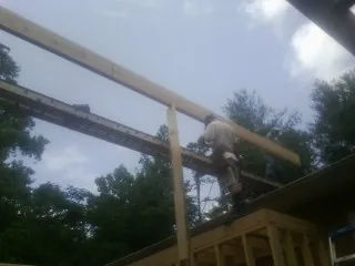 Carpenter setting a ridge beam over a new addition frame — Ice Dam Removal by Roofing Brothers in Olivehurst